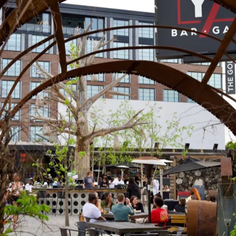 The Yard at Corktown: Guests at tables on the outdoor patio under The Yard signage