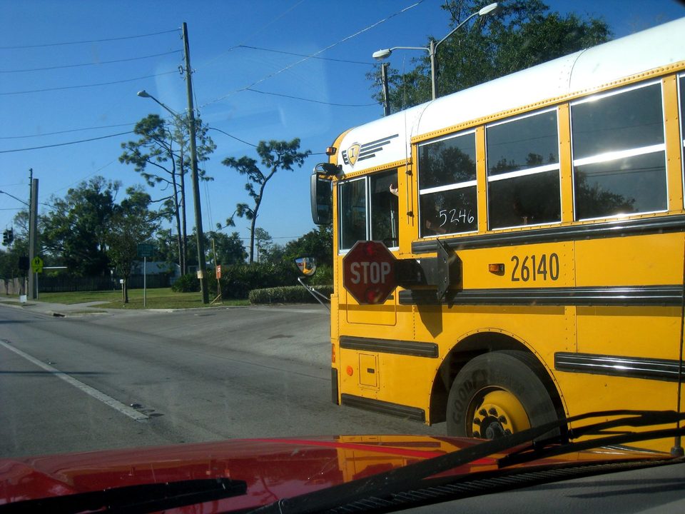 A yellow school bus with its STOP arm out
