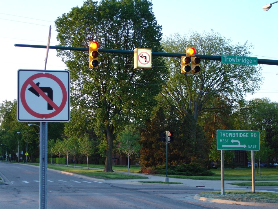 Lit no-left-turn signs and a Michigan left guide sign in East Lansing