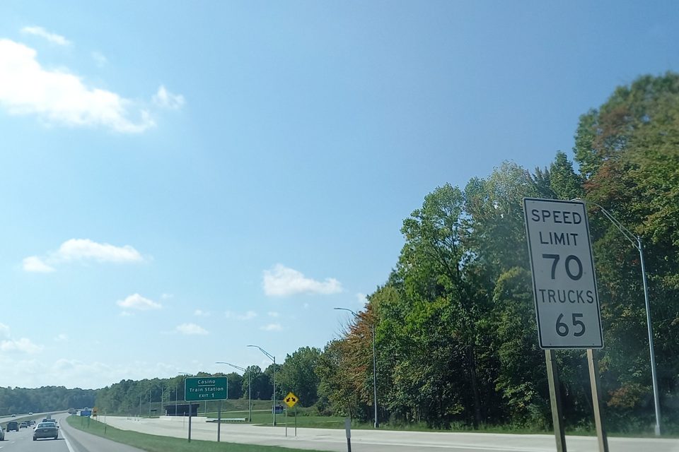 A SPEED LIMIT 70, TRUCKS 65 sign on a Michigan freeway
