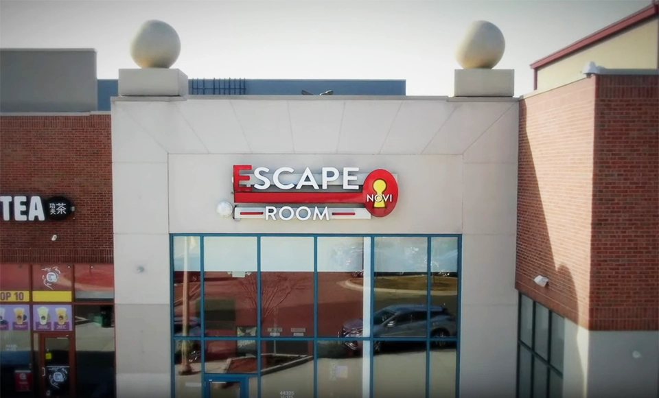 Escape Room Novi's entrance with its red keyhole sign in a shopping strip