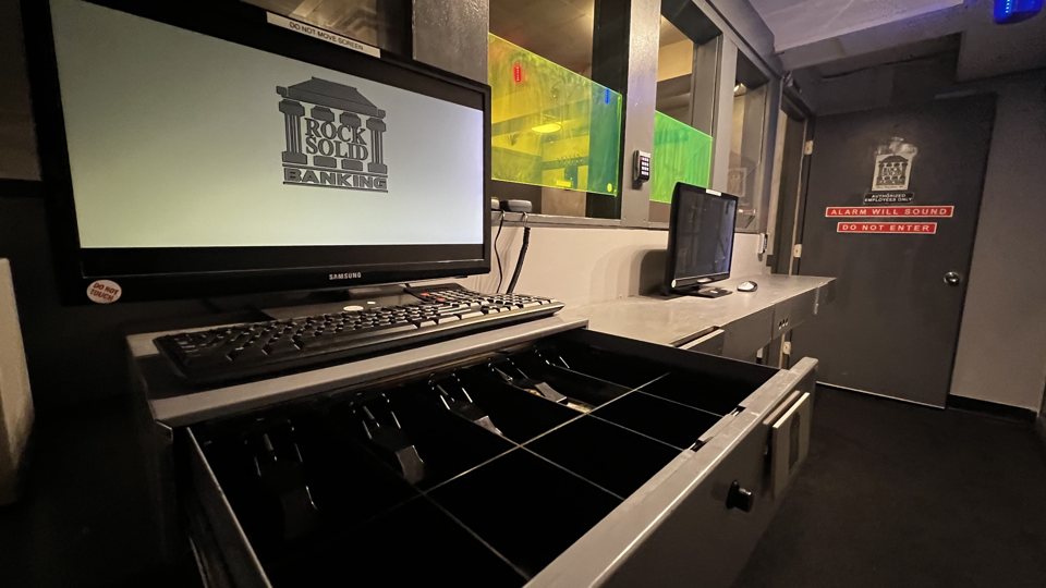 Banki pénztárpult monitorral és nyitott kasszafiókkal a bank témájú szobában