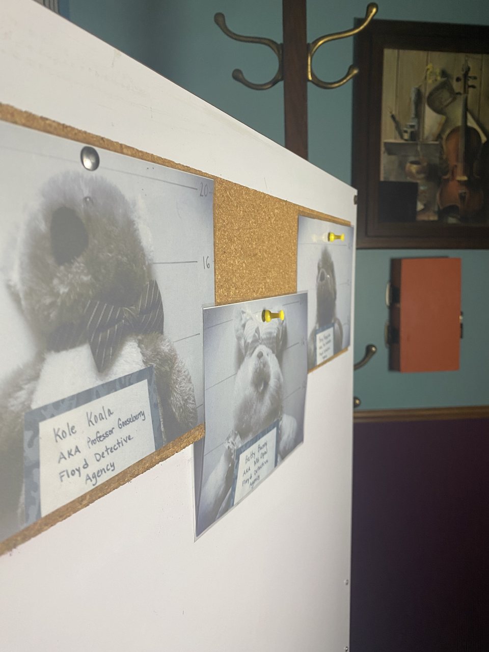 Clue board with pinned mugshot-style photos of stuffed animals and handwritten name cards