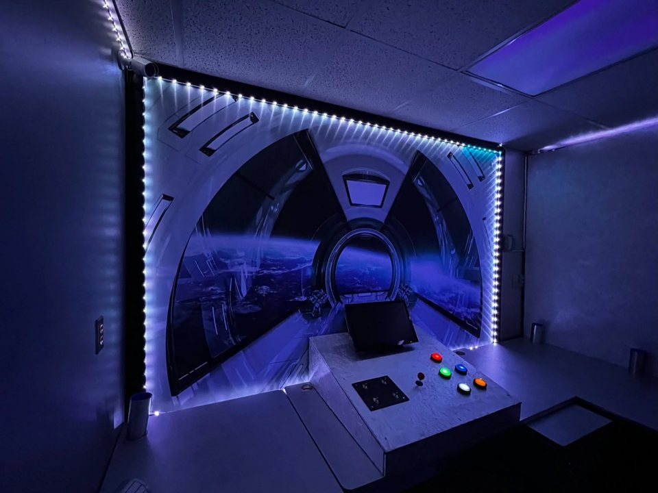 Spaceship cockpit set with an LED-framed window view of Earth and a control desk with colored buttons