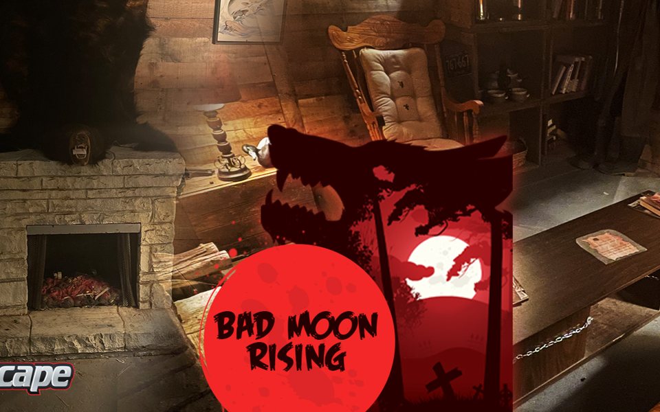 Wood-paneled hunting cabin set with a stone fireplace, a bearskin, a rocking chair and a chained coffee table on the Bad Moon Rising room banner