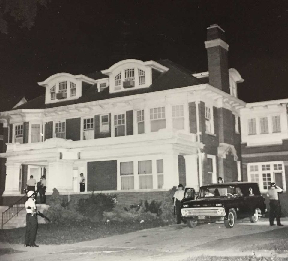 Az Algiers Motel melléképülete, egy tetőablakos téglaház, előtte rendőrökkel és egy autóval 1967. július 26-án éjjel