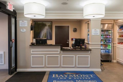 The front desk by the entrance with a Baymont doormat