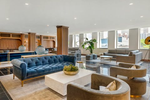 The lobby with a blue tufted sofa, armchairs and large windows