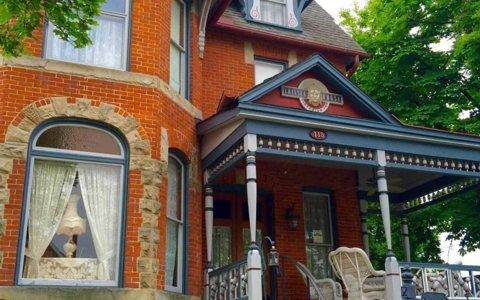 The house's ornate porch and arched windows