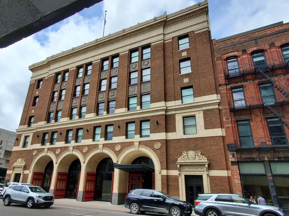 The hotel's red-brick building, the former Detroit Fire Department headquarters, with its arched bays on Larned Street