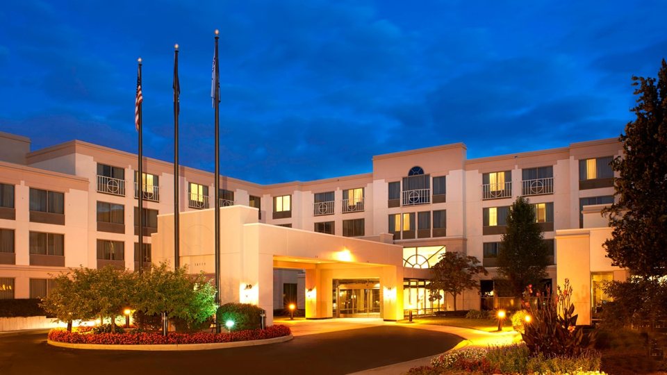The entrance and facade of the airport Marriott hotel lit up at dusk