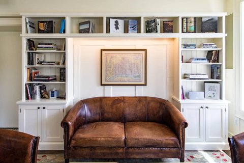 A leather sofa in front of bookshelves and an old map of Detroit in the lounge