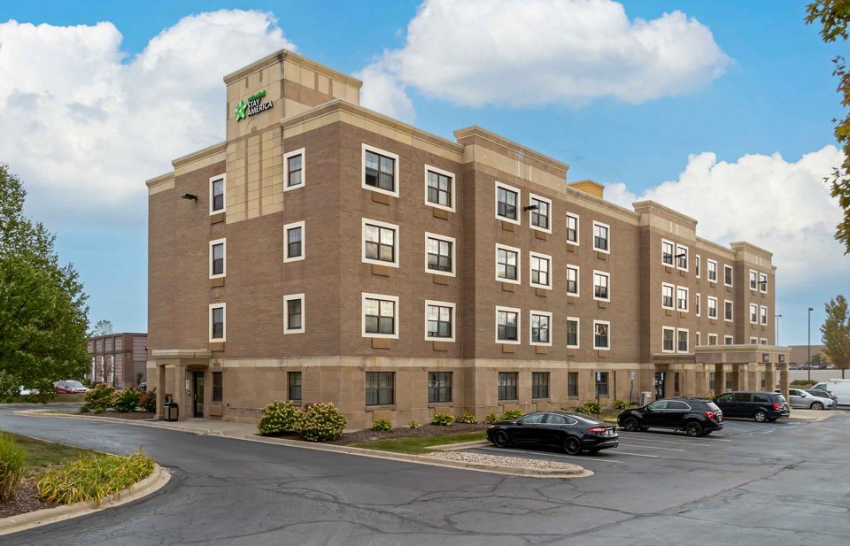 The hotel's brick building and parking lot in sunshine