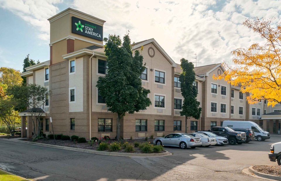 The hotel building with autumn trees and a parking lot