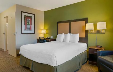 A guest room with a large bed and a green wall