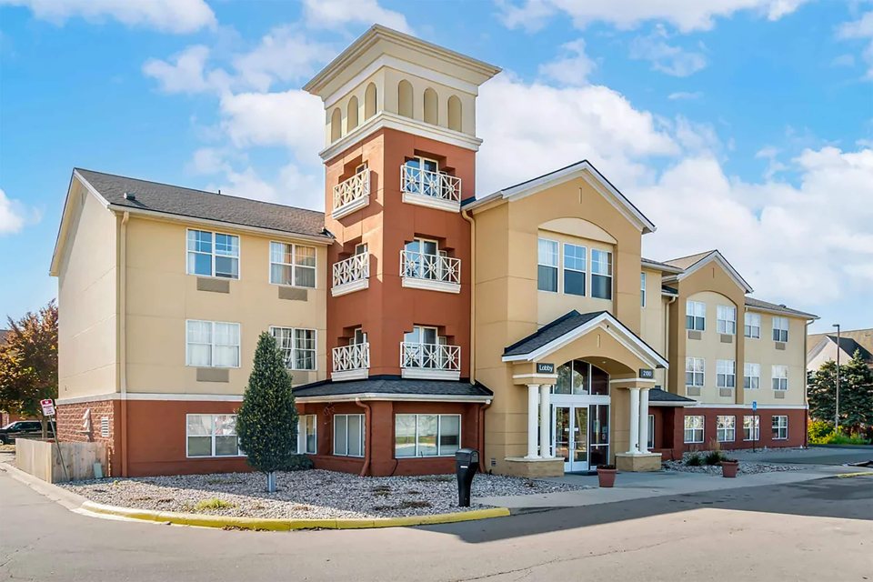 The hotel's tan facade with a tower under a blue sky