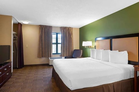 A guest room with a bed and green accent wall