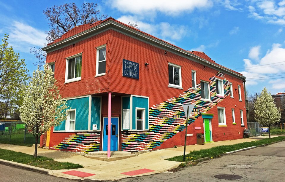 The Hostel Detroit brick building with its colorful painted pattern in spring