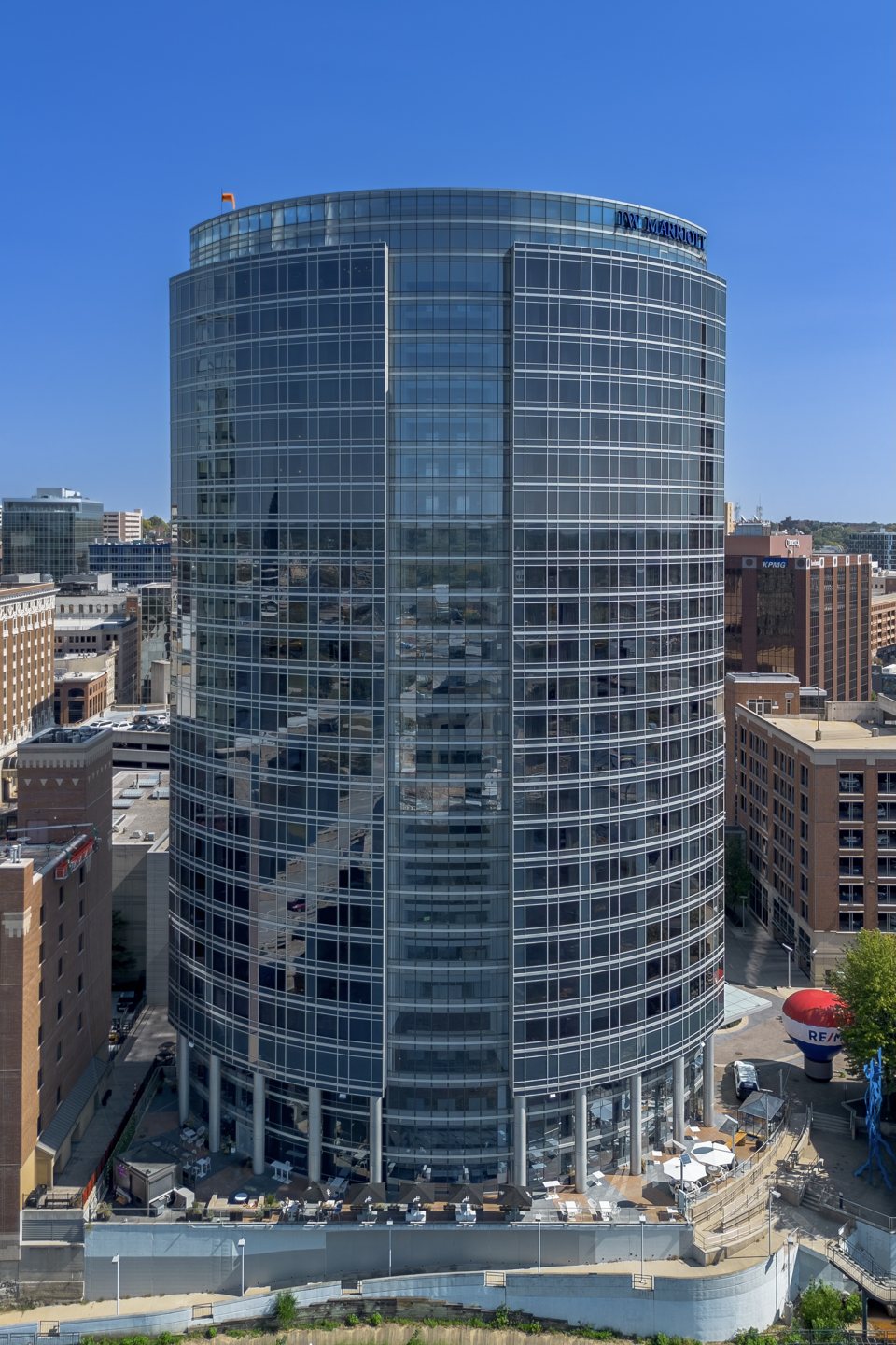 The curved glass tower of the JW Marriott Grand Rapids under a blue sky
