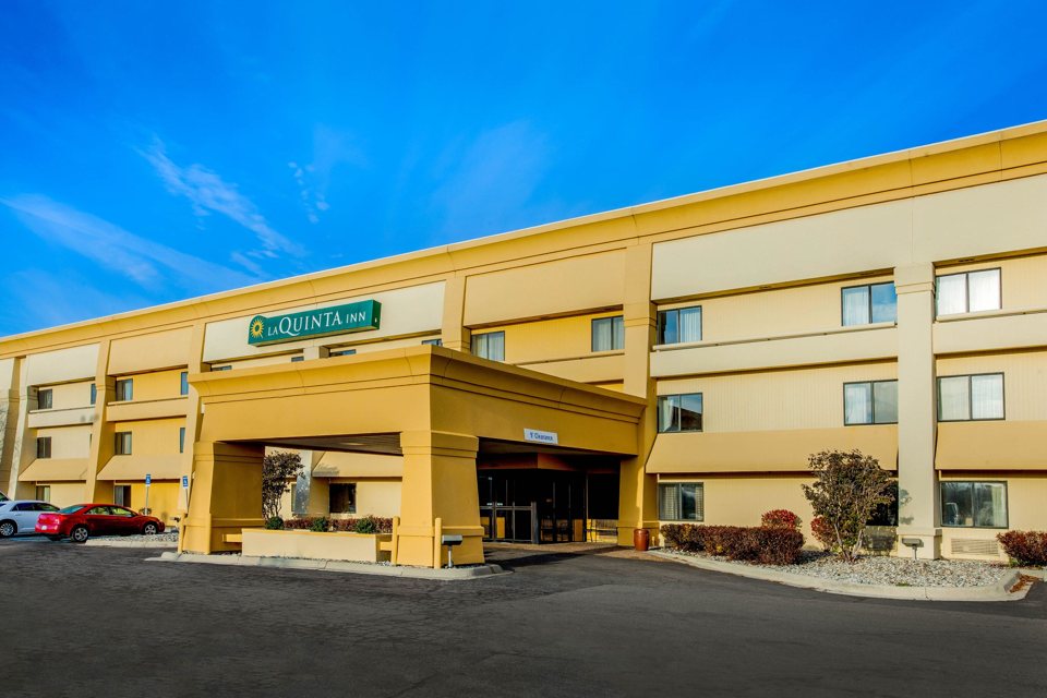 The La Quinta Inn's yellow building with its entrance canopy by day