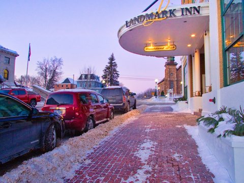 The Landmark Inn's curved signed canopy above a snowy brick sidewalk