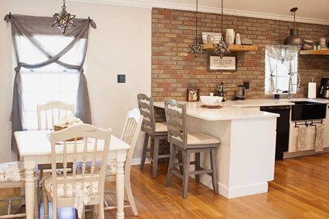 An open kitchen and dining nook with a brick wall