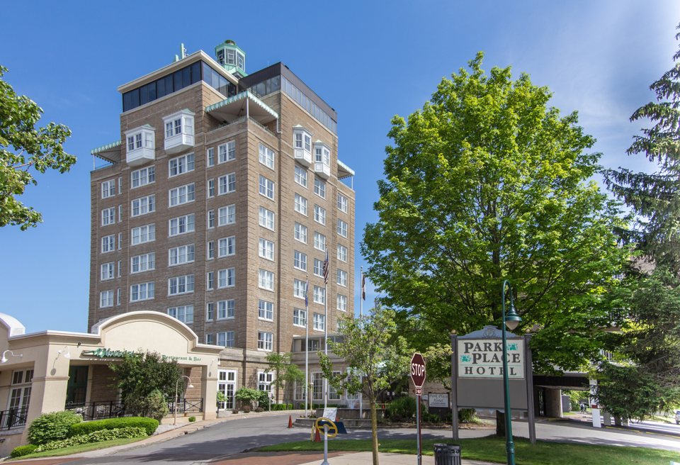 The Park Place Hotel's brick tower with its green-domed top, the name sign by the entrance and leafy trees