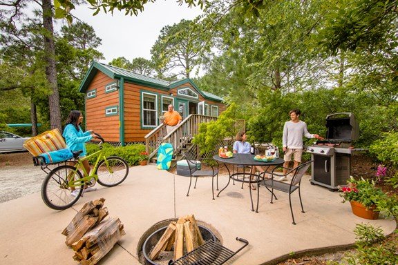 A cabin with a fire pit and a bicycle on the campground