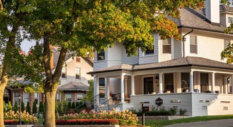 The inn's white facade with a garden beneath autumn trees