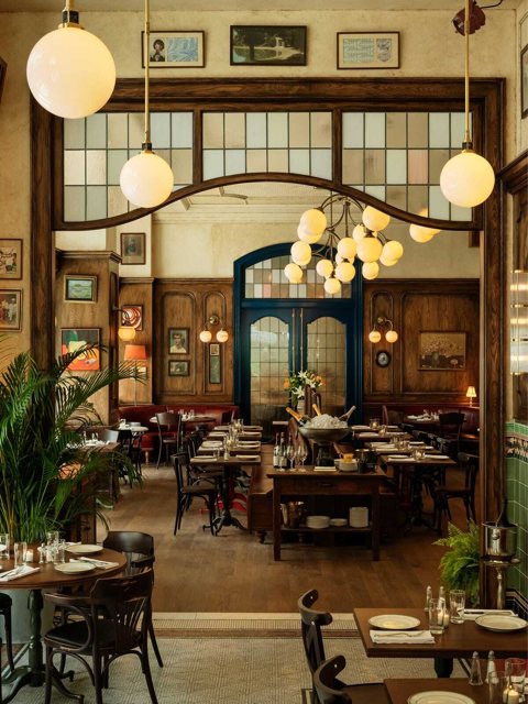A Book Tower földszinti brasserie-je gömblámpákkal, faburkolattal és terített asztalokkal
