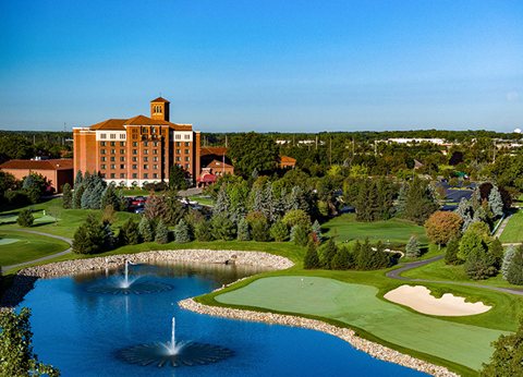 Aerial view of the hotel building and the golf course pond with fountains