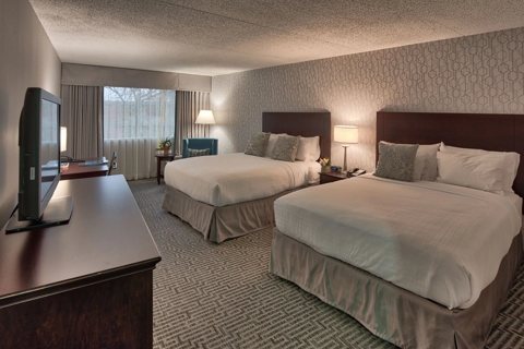 A guest room with two queen beds and a desk