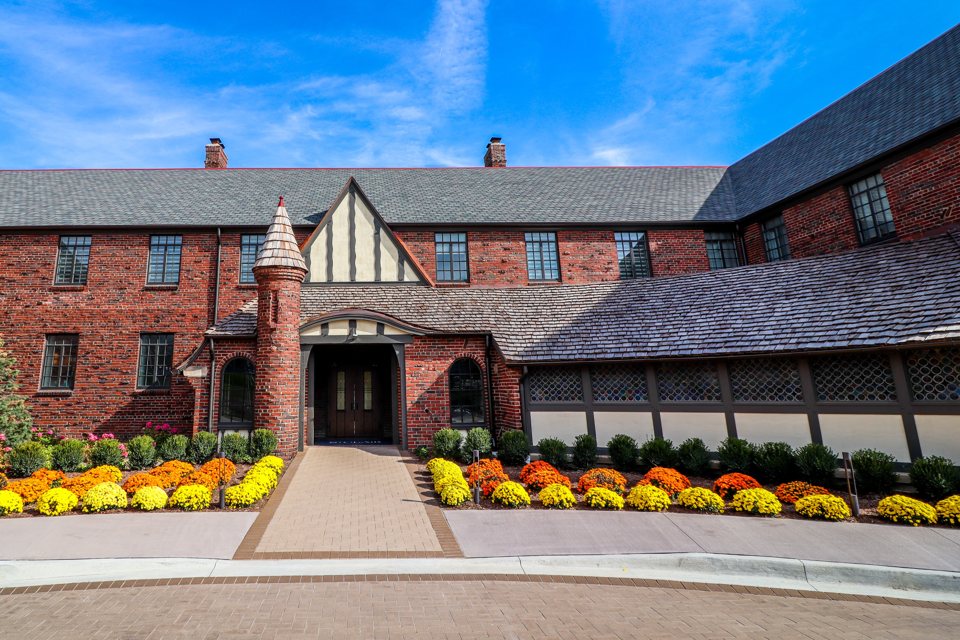 The St. Clair Inn's Tudor-style brick facade and entrance with flower beds