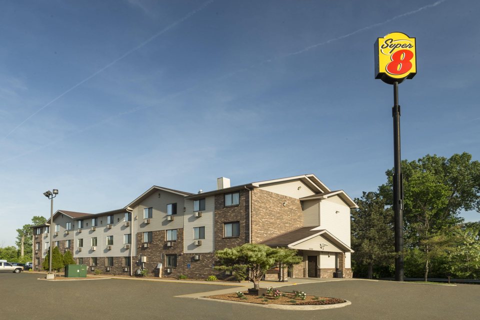 The three-storey Super 8 hotel and its tall sign seen from the parking lot