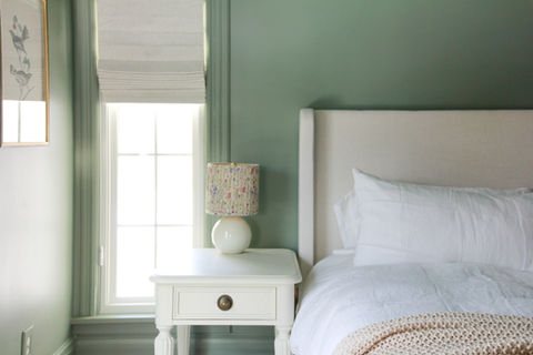Guest bedroom with sage-green walls and a bed