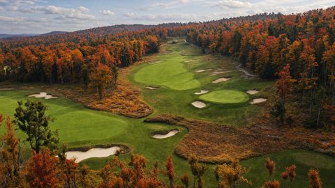 Az üdülő egyik golfpályája őszi erdők között, felülről