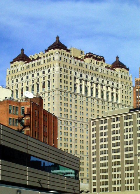 The Book Cadillac's beige brick tower with its turreted roofline under a blue sky
