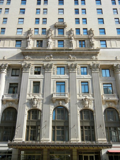 The lower floors of the facade with statues, columns and arched windows
