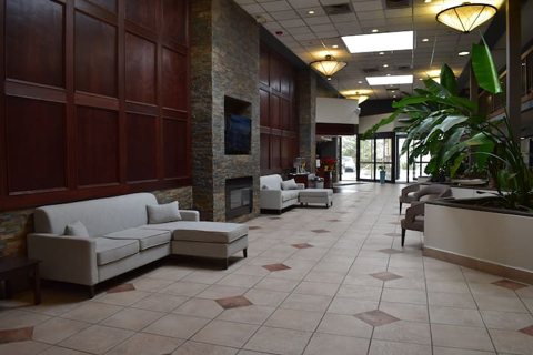 The lobby with a stone fireplace, sofas and a tiled floor