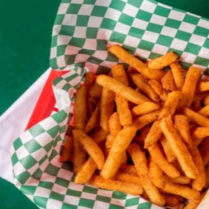 Seasoned fries in a checkered paper-lined basket