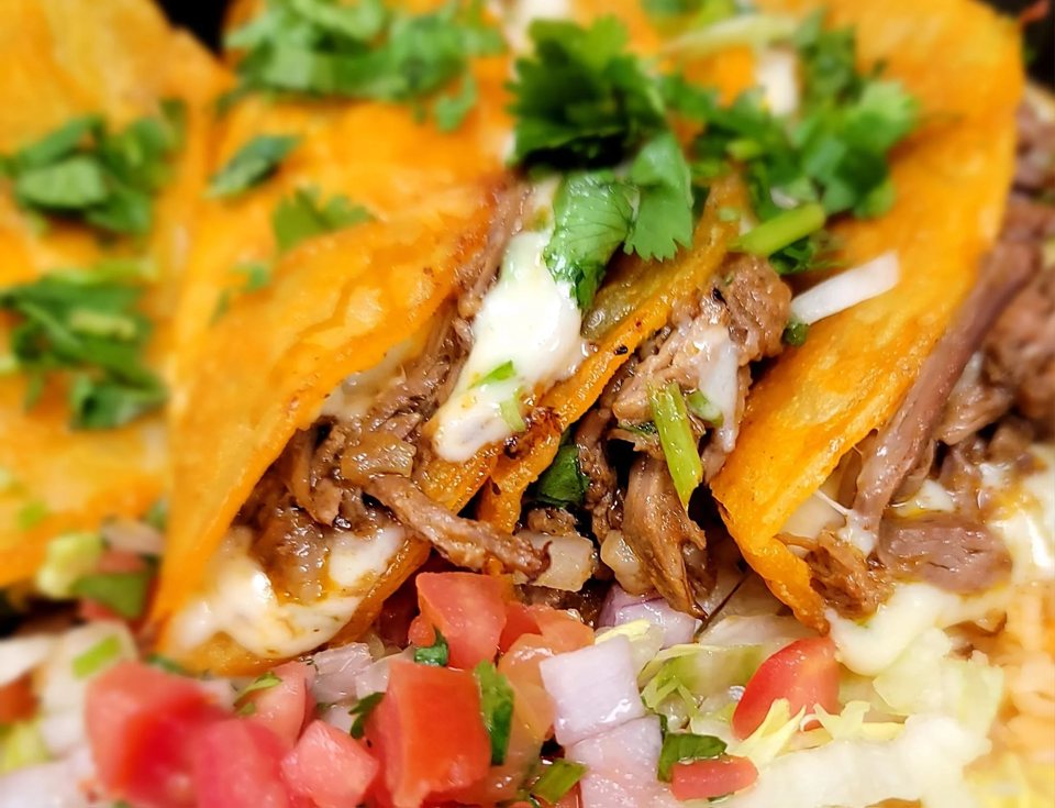 Meat tacos with cilantro, diced tomatoes and onions