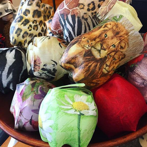 Upcycled bottle boxes decorated with animal and floral prints in a wooden bowl