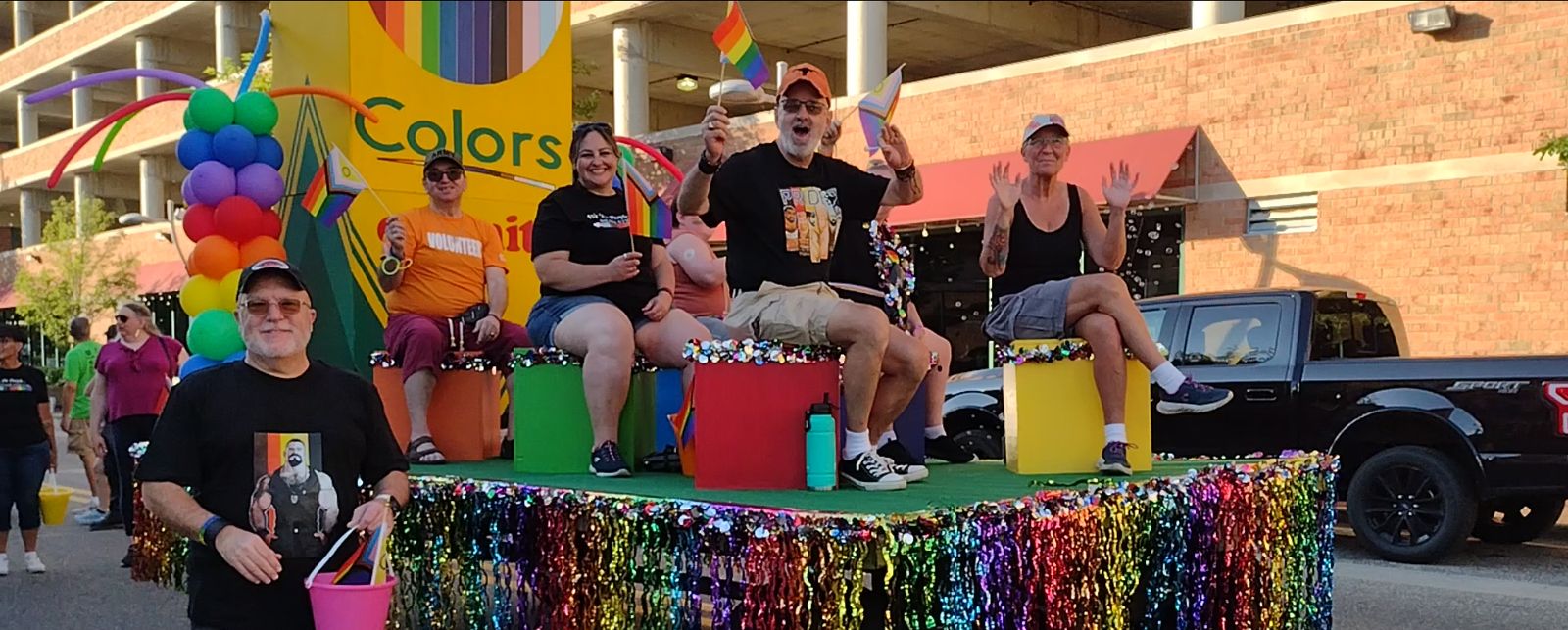 Rainbow-decorated float with riders in a Pride parade