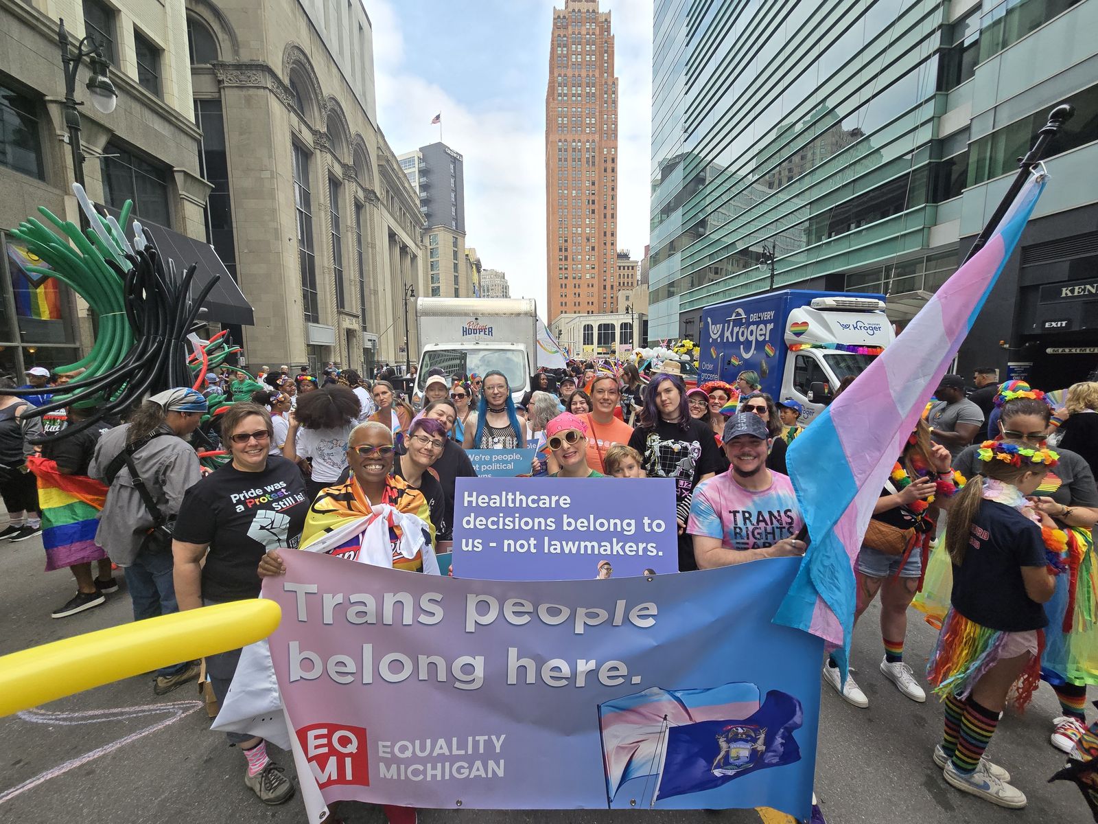 Felvonulók „Trans people belong here” transzparenssel egy belvárosi Pride-menetben
