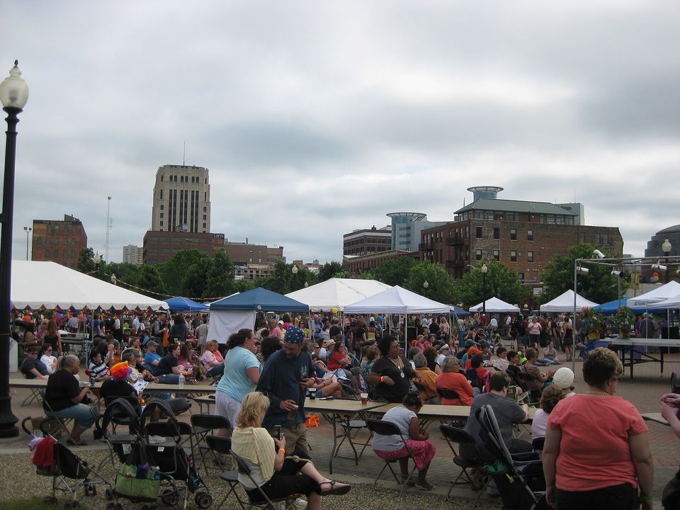 Asztaloknál ülő közönség a Kalamazoo Pride 2011-en, háttérben a belváros