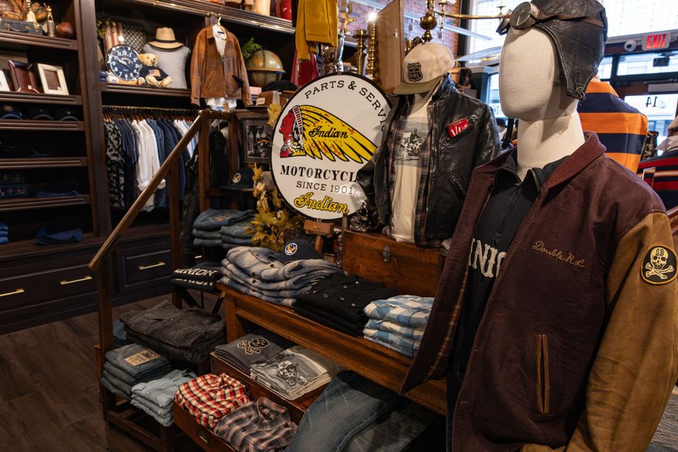 Menswear display with leather jackets, sweaters and a mannequin in an aviator cap