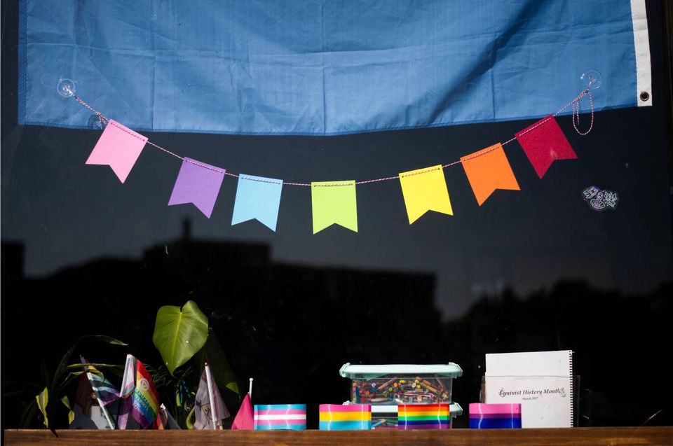 Colorful pennant bunting and small Pride flags on a shelf in the center