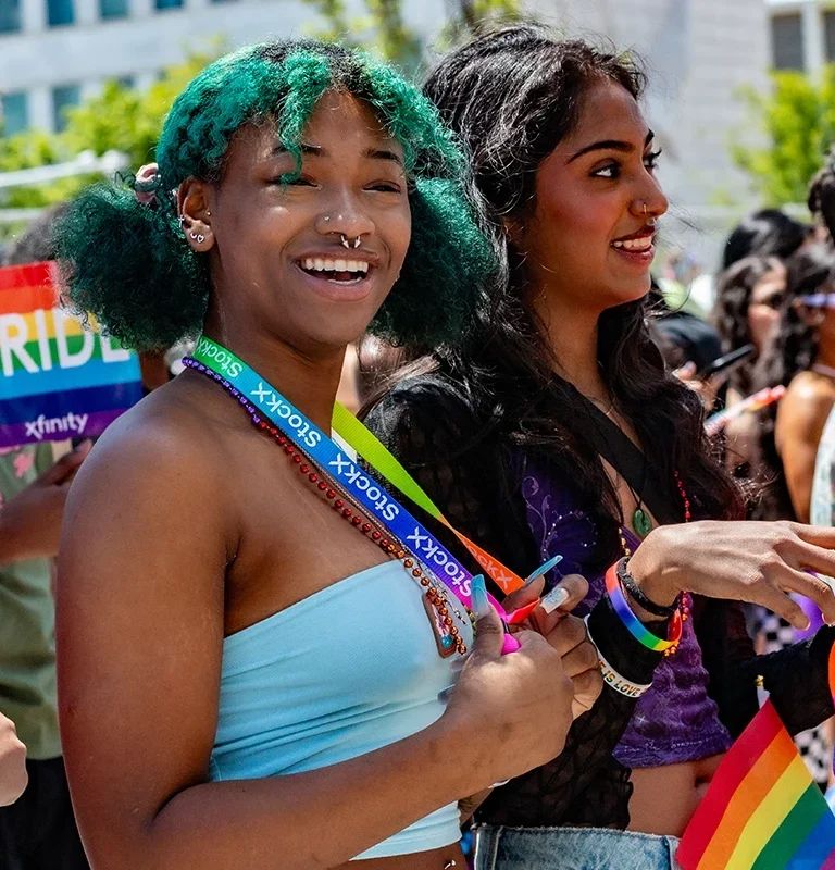 Mosolygó résztvevők szivárványos kiegészítőkkel a Motor City Pride-on