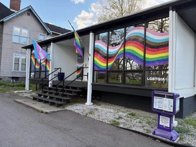 Rainbow window art and Pride flags on the OutFront Kalamazoo building