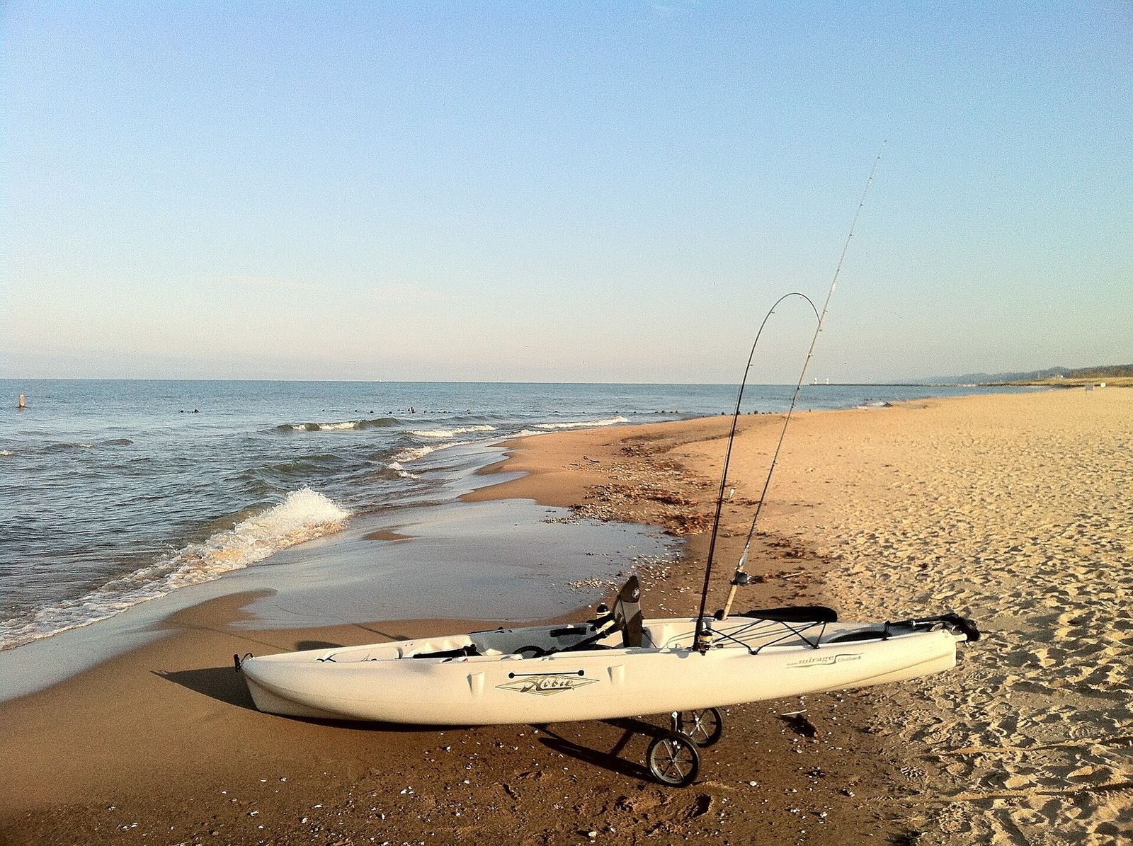 Sandy shoreline with a kayak and fishing rods at Oval Beach, Saugatuck